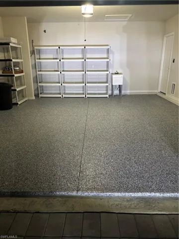 Garage featuring Epoxy coating and a garage door opener and baseboards
