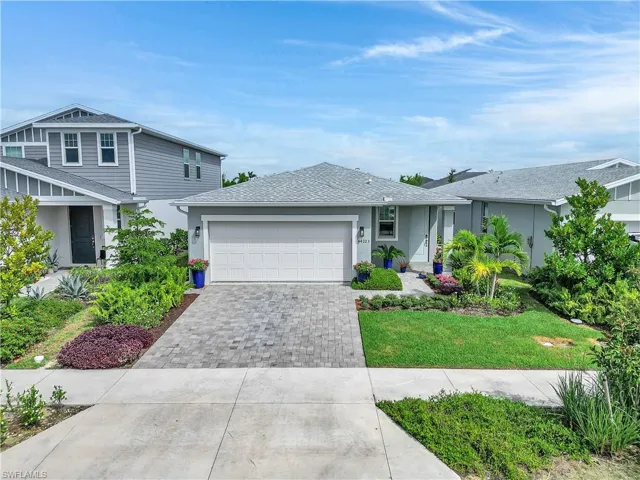View of front of home featuring decorative driveway, a garage, roof with shingles, and stucco siding