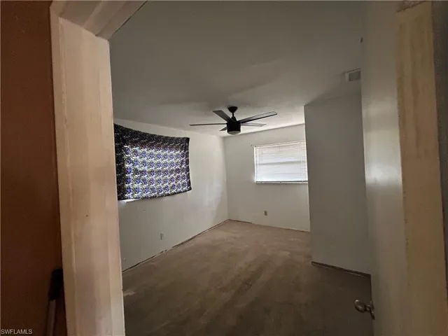 Unfurnished room with visible vents and a ceiling fan