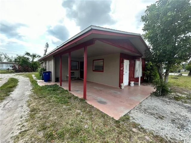 View of side of property featuring a carport and stucco siding