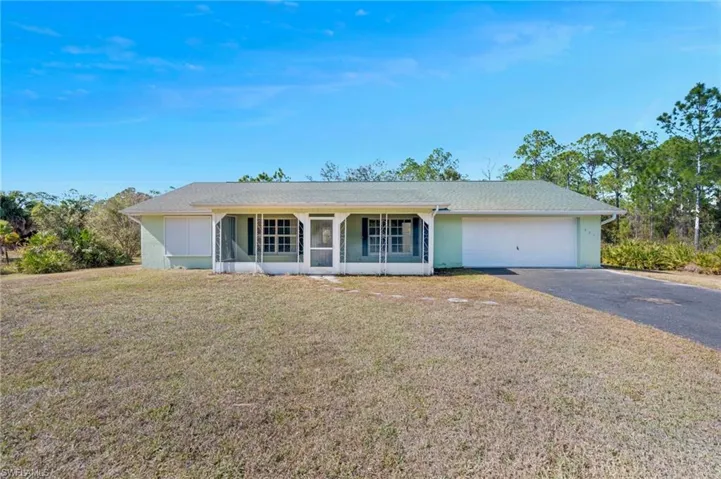 Ranch-style house with driveway, a front lawn, a porch, and a garage