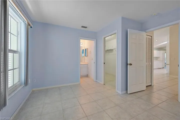 Unfurnished bedroom featuring a spacious closet and light tile patterned floors