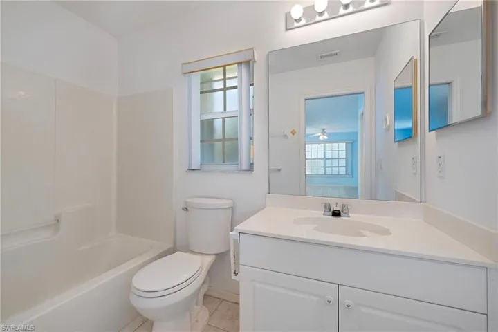 Bathroom featuring vanity, tub / shower combination, and light tile patterned floors