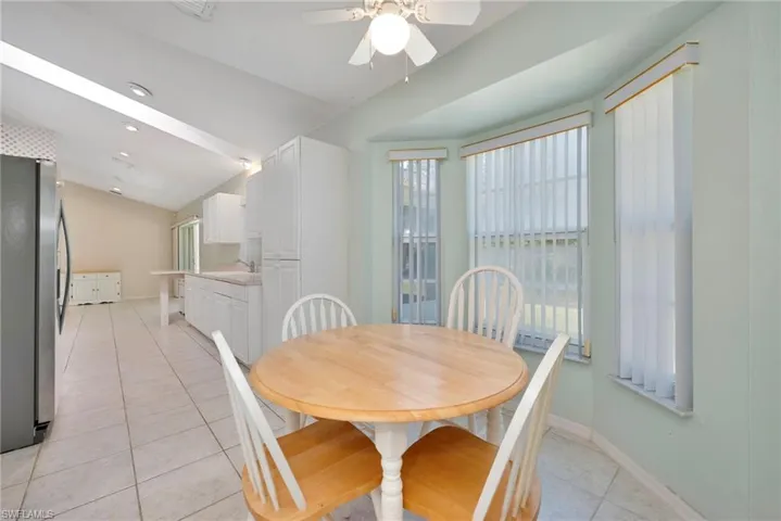 Dining space featuring light tile patterned floors, lofted ceiling, ceiling fan, and recessed lighting