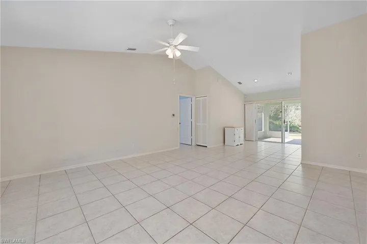 Spare room with high vaulted ceiling, light tile patterned flooring, and a ceiling fan