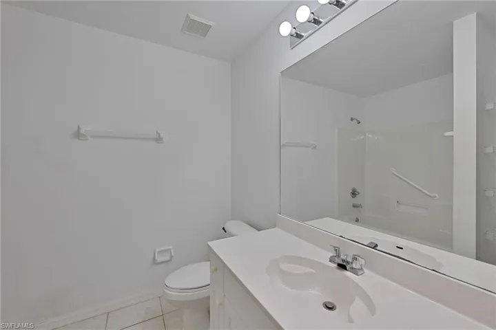Bathroom with vanity, light tile patterned floors, and  shower combination