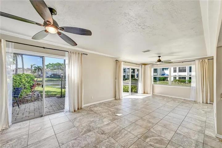Spare room with ceiling fan, a textured ceiling, healthy amount of natural light, and a water view