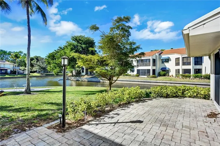 View of home's community with a yard, a water view, and a patio