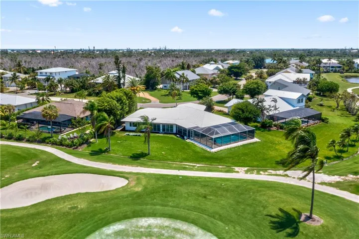 Back of house with a lanai and a yard