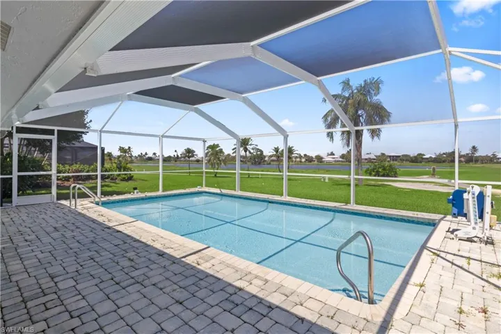 View of pool with a lanai, a patio area, and a yard