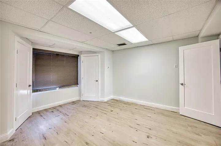 Empty room featuring a paneled ceiling and light wood-type flooring