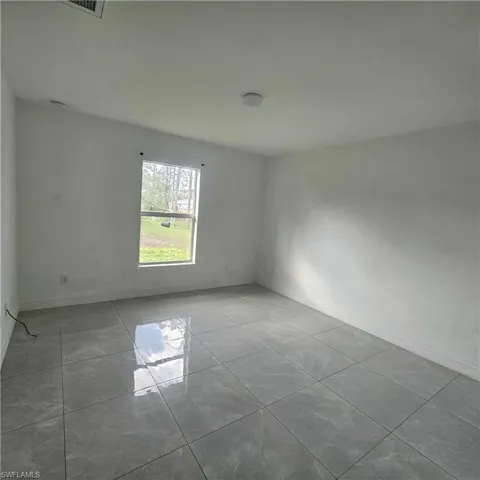 Spare room with baseboards and light tile patterned floors