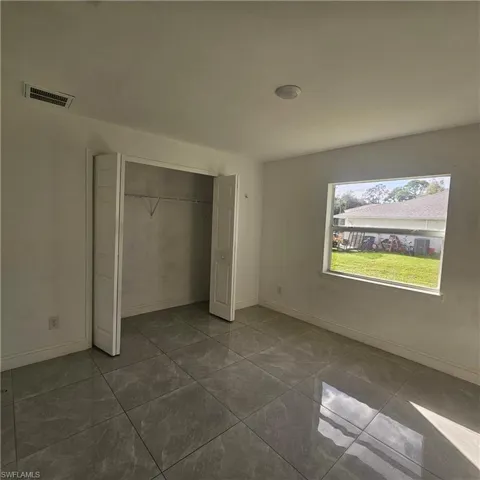 Unfurnished bedroom featuring a closet and baseboards