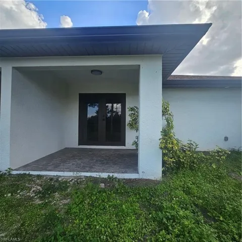 Property entrance with french doors and stucco siding