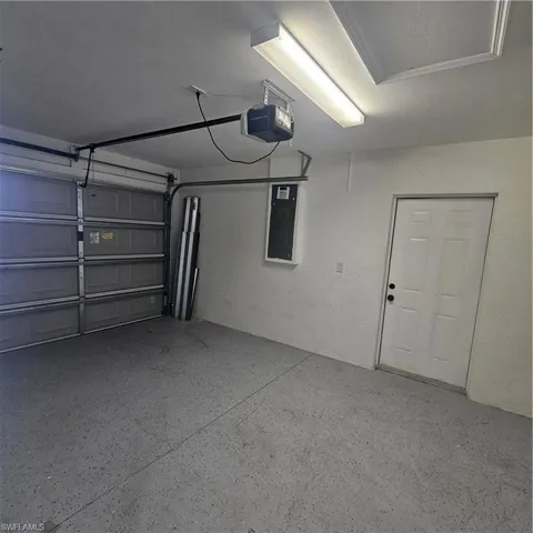 Garage with electric panel and a garage door opener