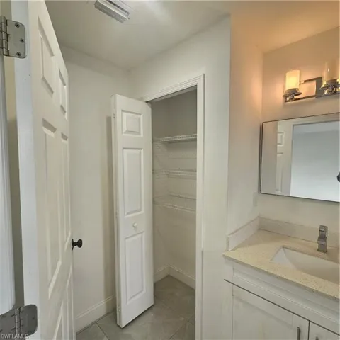 Bathroom featuring vanity and dark tile patterned floors