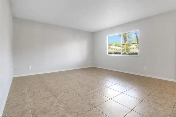 Spare room featuring tile patterned floors and baseboards