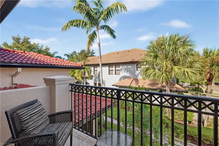 Balcony featuring a black wrought iron railing, tiled flooring, and stucco exterior
