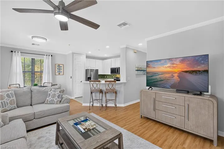 Wood-finish laminate flooring, a contemporary ceiling fan and crown molding