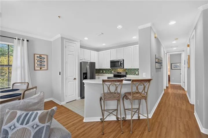 Kitchen featuring white cabinetry, stainless steel appliances, and a tile backsplash