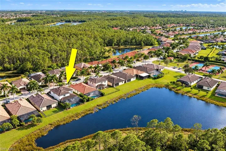 Aerial perspective showcasing a residential property with a tile roof, screen-enclosed pool, and expansive water frontage