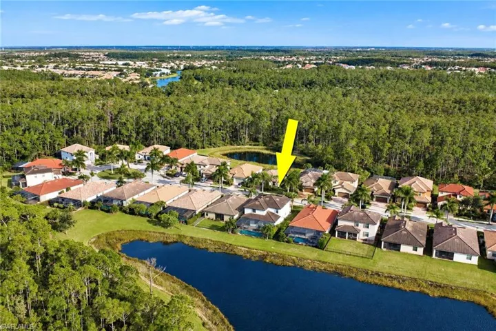 Aerial perspective of residential property featuring a tiled roof, multi-level structure, paved driveway, and established landscaping