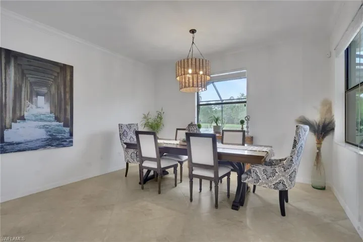 Neutral-toned tile flooring, multi-tiered beaded chandelier, and oversized window with screen enclosure