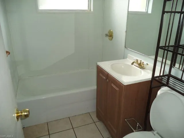 Bathroom with toilet, vanity, and tile patterned floors