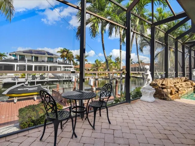 View of patio / terrace with a lanai, a water view, and a boat dock
