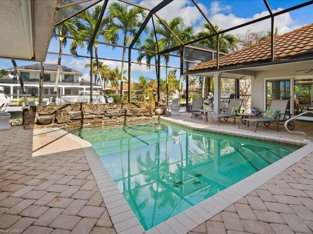 View of pool featuring a patio and glass enclosure