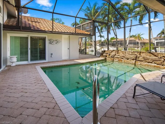 View of swimming pool featuring a lanai and a patio