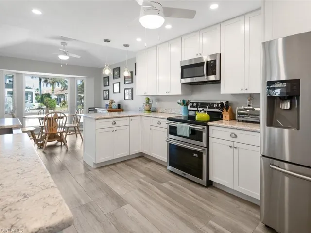 Kitchen with stainless steel appliances, white cabinets, and kitchen peninsula