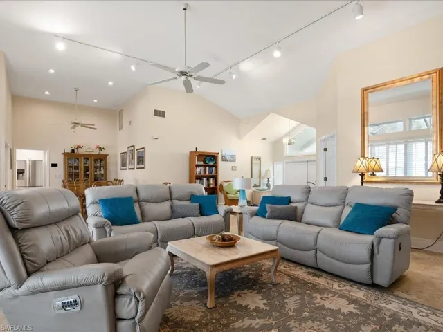 Living room featuring high vaulted ceiling, ceiling fan, and rail lighting