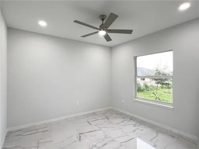 Room featuring large-format tile flooring, a ceiling fan with integrated lighting, and recessed ceiling lights