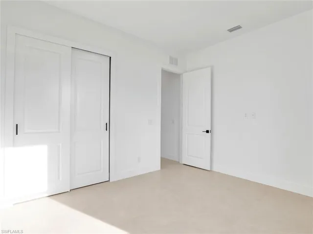 Unfurnished bedroom featuring a closet, visible vents, and baseboards