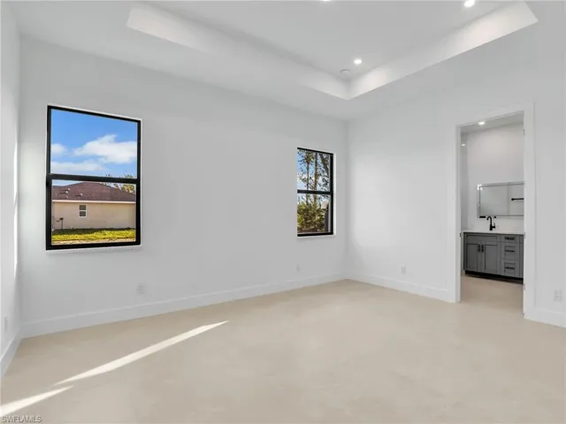 Spare room with recessed lighting, a raised ceiling, and baseboards