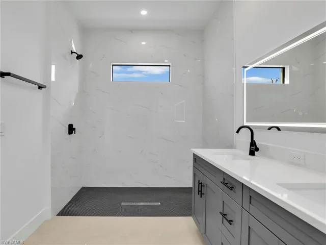 Full bath featuring recessed lighting, walk in shower, a sink, and double vanity