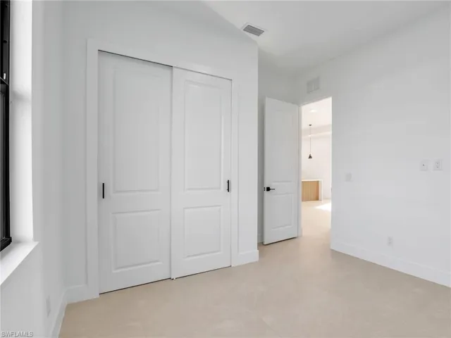 Unfurnished bedroom featuring a closet, visible vents, and baseboards