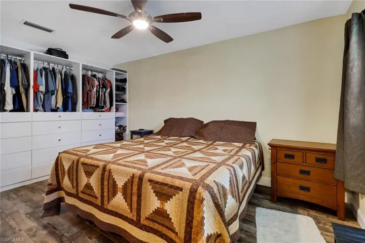 Bedroom with ceiling fan and dark hardwood / wood-style flooring