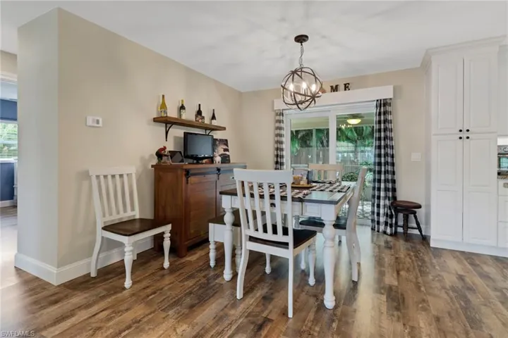 Dining room featuring plenty of natural light, dark wood-type flooring, and a chandelier