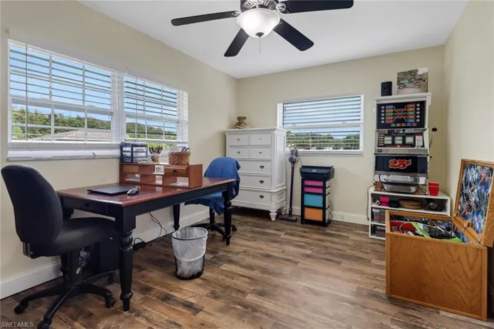 Home office with ceiling fan and dark wood-type flooring