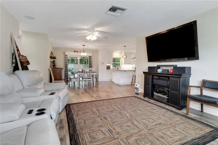 Living room featuring hardwood / wood-style flooring and ceiling fan with notable chandelier