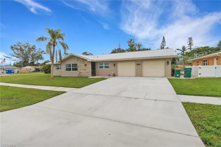 Ranch-style home featuring a garage and a front lawn