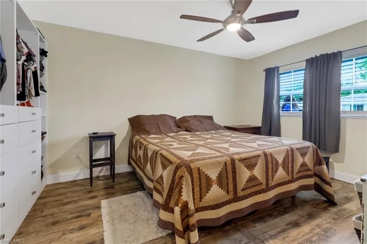 Bedroom with ceiling fan and dark wood-type flooring