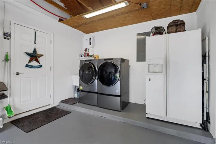 Laundry room featuring independent washer and dryer and electric panel