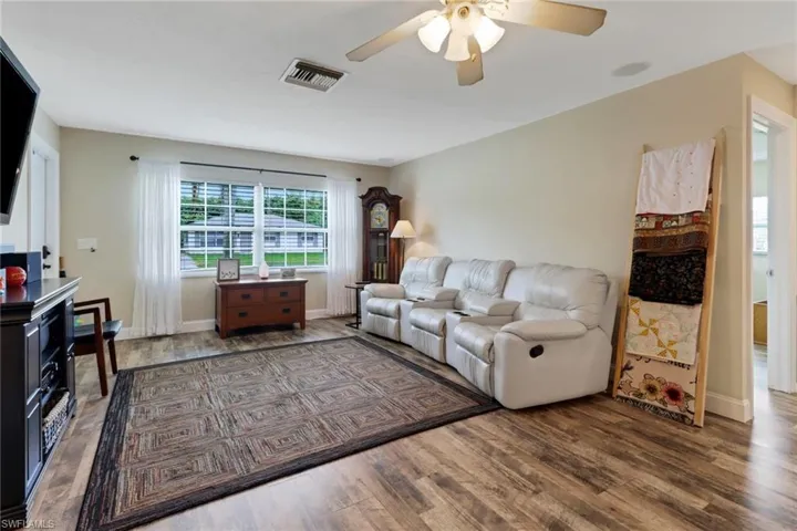 Living room with dark hardwood / wood-style floors and ceiling fan