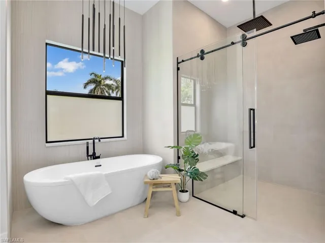 Full bathroom with a stall shower, a freestanding tub, visible vents, and tile patterned floors
