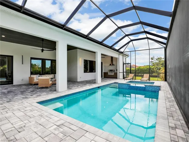 View of pool featuring a lanai, outdoor lounge area, a patio, and ceiling fan