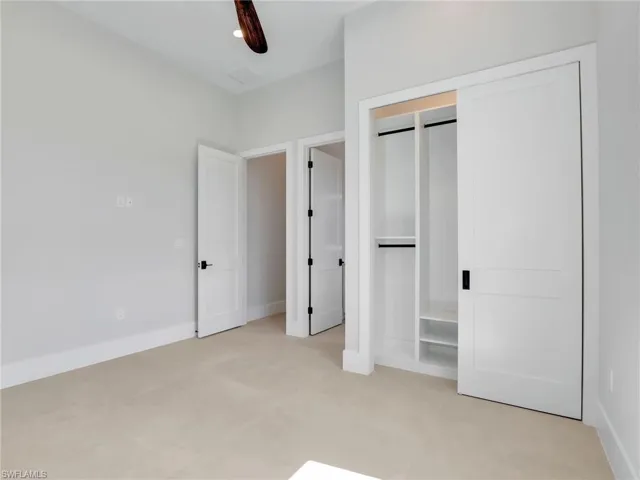 Unfurnished bedroom with a closet, a ceiling fan, and baseboards