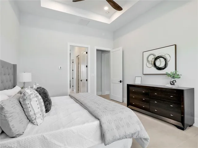 Bedroom with ceiling fan, a tray ceiling, and recessed lighting